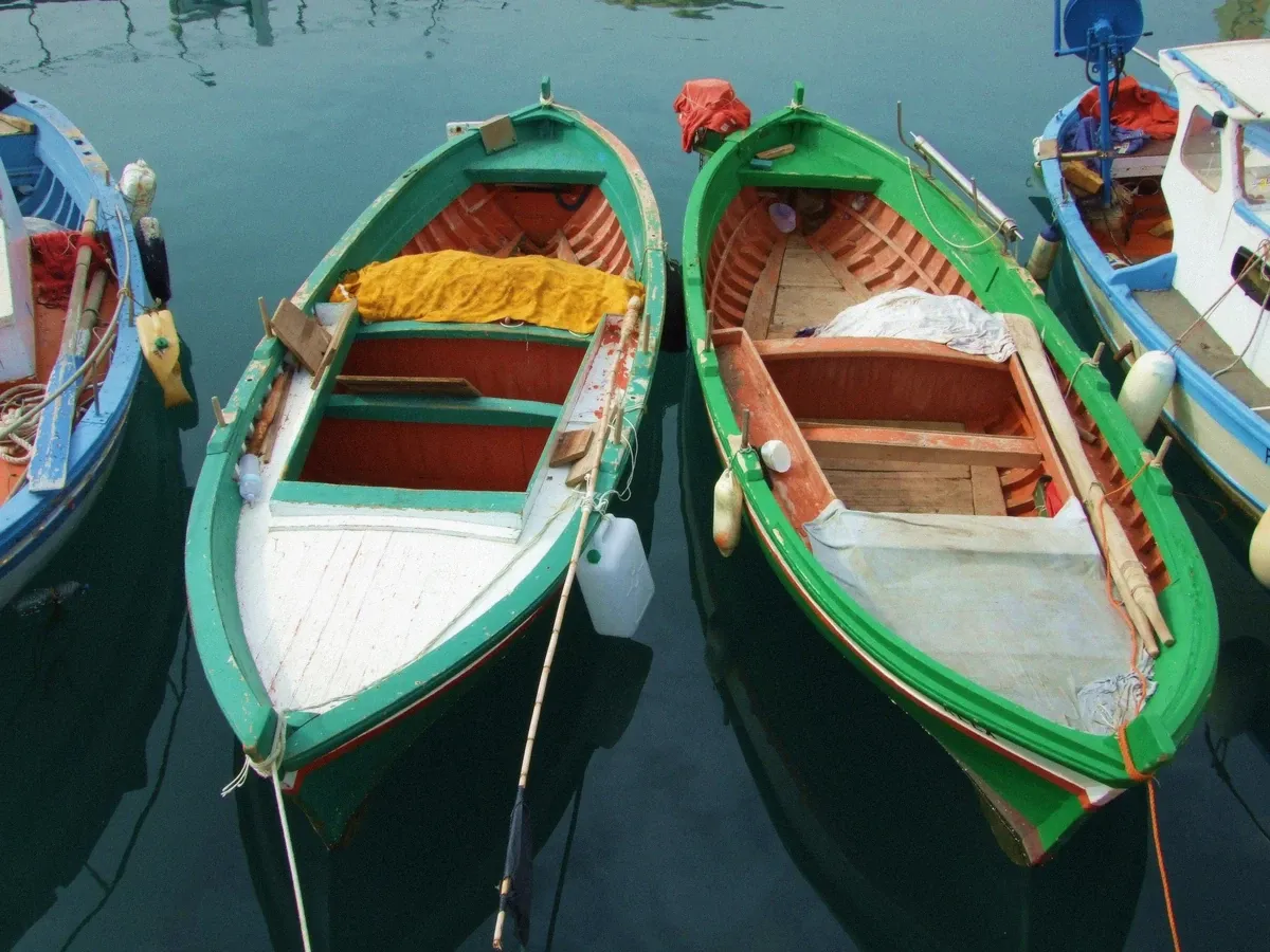 Traditional wooden gozzo boat moored in a Mediterranean harbour, the boat type used for the private Cagliari charter