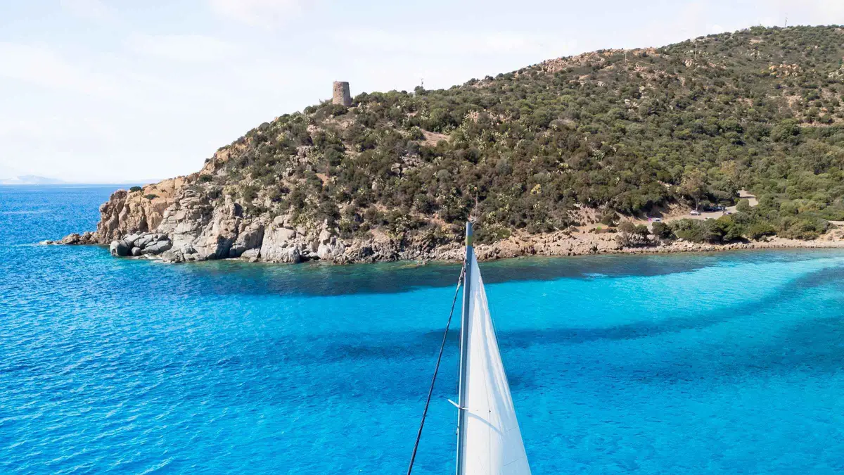 Sailing yacht anchored in the turquoise cove of Mari Pintau on a full-day Cagliari sailing trip, Sardinia